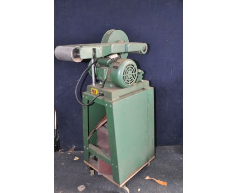 A MULTICO BELT AND DISC SANDER on a rolling stand with a quantity of sanding belts and discs along with a smaller unbranded b