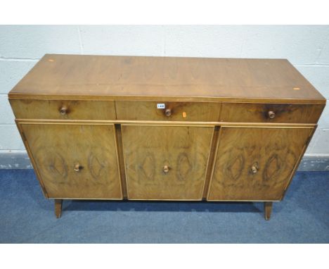 A MID CENTURY WALNUT SIDEBOARD, with three drawers above three cupboard doors, length 135cm x depth 48cm x height 90cm (condi