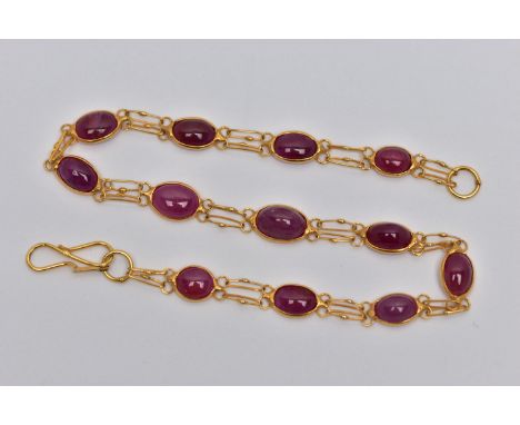 A YELLOW METAL AND RUBY SPECTACLE SET BRACELET, comprised of twelve slightly graduated oval cabochon rubies, each set in open
