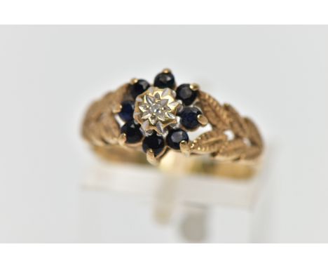 A 9CT GOLD DIAMOND AND SAPPHIRE CLUSTER RING, the illusion set single cut diamond, within a circular cut sapphire surround, t