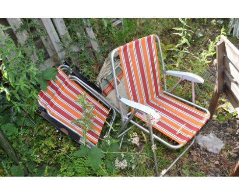A PAIR OF VINTAGE METAL FOLDING GARDEN CHAIRS with striped covering in a canvas cover and three more recent folding chairs wi