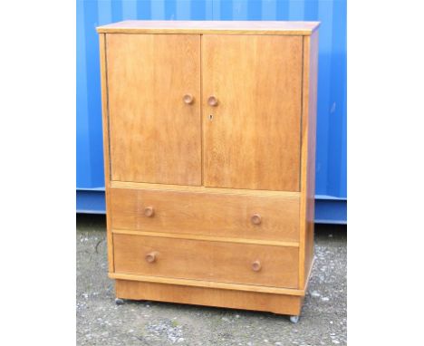 A 1960s light oak cupboard with closed shelves over two drawers.  37cm deep, 86cm wide, 122cm high.  