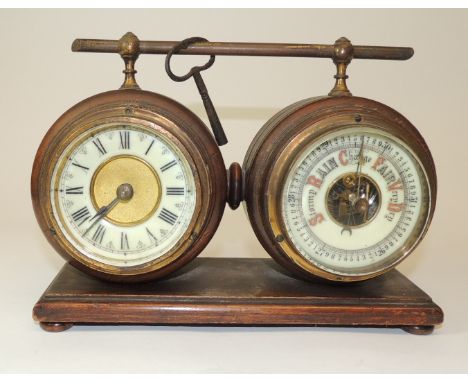 A HAC Germany desk clock and barometer mounted side by side in circular turned wood cases with brass carrying bar, the back o