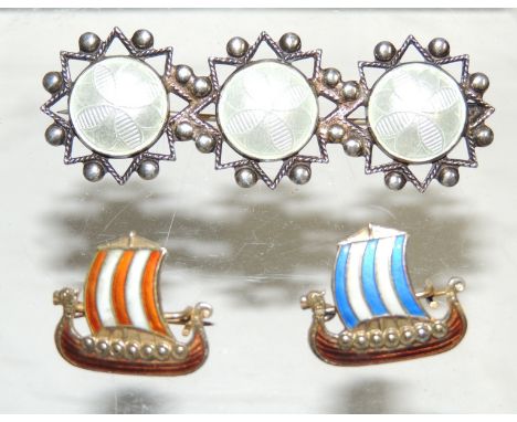A Norwegian silver and enamel brooch by "ARNE NORDLIE" OSLO, three white enamel circles, each set in star and ball silver sur