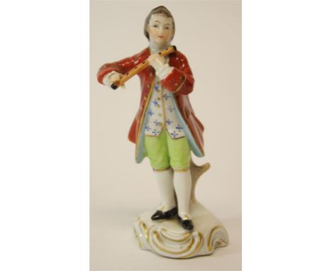 A Sitzendorf porcelain figurine, of a young man playing a wind instrument on a circular base with gilt scroll detail.  11 cm 