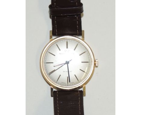 A Gents 9ct gold cased "PERRY GREAVES" manual wind wristwatch on leather strap.  The white dial with gold baton numerals, bla