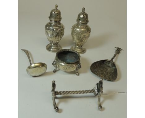 A pair of silver pepperettes with embossed swag decoration; a squat circular silver salt; a small silver ladle; a silver meta
