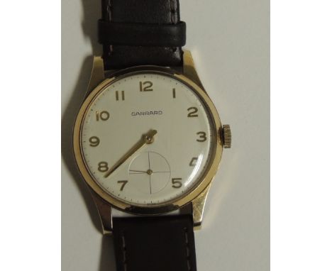 A Gents 9ct gold cased, manual wind wristwatch, the dial marked "GARRARD".  The white dial with gilt arabic numerals and seco