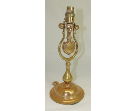 A late 19th/early 20th Century brass electric wall/table lamp, the stepped circular base with hanging loop and the light fitt