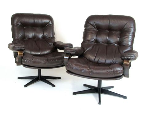 A pair of 1970's brown leather button upholstered armchairs with bentwood frames and five star swivel bases