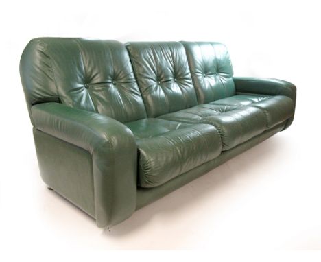 A 1970s green leather button back lounge suite including a three seater sofa and two matching armchairs