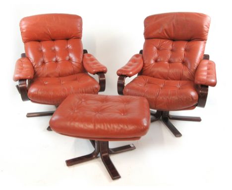 A pair of 1970's tan leather button upholstered reclining armchairs on bentwood frames with a matching footstool