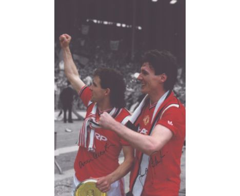 Autographed MAN UNITED 12 x 8 photo : Col, depicting FRANK STAPLETON and ARTHUR ALBISTON celebrating in front of supporters d