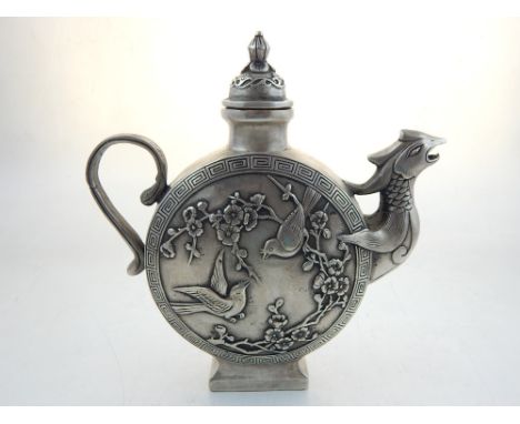 A Chinese white metal teapot, with phoenix spout and scroll handle, decorated with peacock to one side and birds among flower