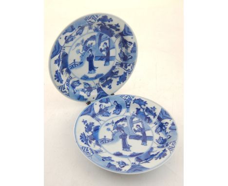A pair of small Chinese Kangxi style blue and white dishes, decorated with vignettes of women in garden settings, bears six c
