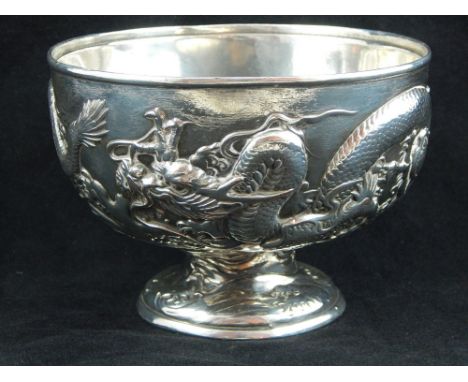 A Chinese white metal bowl, embossed with a continuous design of dragons chasing a flaming pearl, 42ozt. D. 15cm
