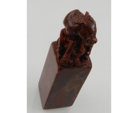 A Chinese soapstone seal mark, carved with dogs of Fo finial. H. 11cm