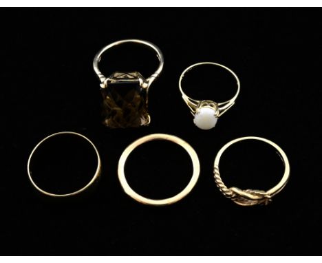 Two wedding bands, three other rings, including a opal and a smoky quartz ring all in 9 ct gold 