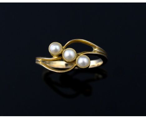 An Edwardian ring set with pearls, collet set with three half pearls, in 18ct gold 