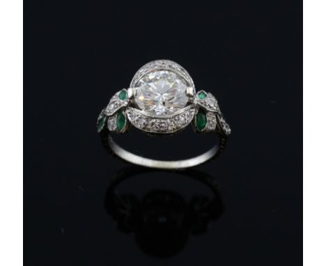 An Art Deco emerald and diamond ring, an Old European-cut diamond to the centre weighing approximately 1.90 carats  with a di