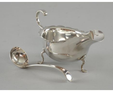 Edward VII silver cream boat with serpentine rim, scroll handle on three shaped feet, complete with small cream ladle, by Ric