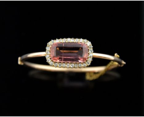 Victorian Imperial pink topaz and diamond bangle, set with an emerald cut pink to orange colour topaz weighing 12.00cts in a 