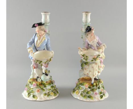 Pair of 19th Century continental lamp figures of a young man and a young woman holding baskets on floral decorated bases.  37