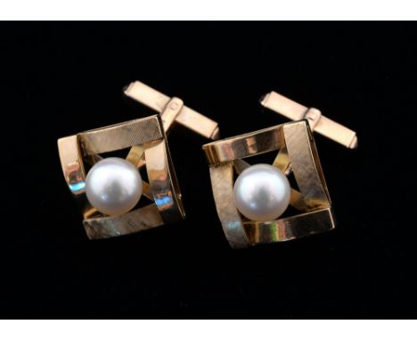 A pair of gold and pearl set cufflinks, square form with plain and textured gold sides and pearl in open setting, reverse wit