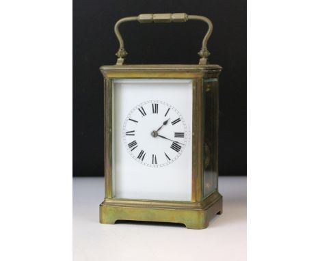 20th Century brass carriage clock having bevelled glass sides, swing handle to top and a roman numeral chapter ring. Measures