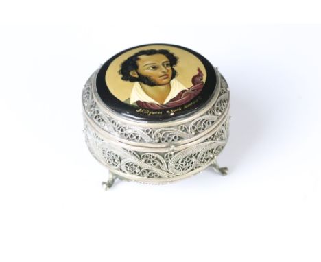 Hand painted circular filigree trinket pot raised on three scroll feet, the hinged lid with hand painted plaque depicting Pus