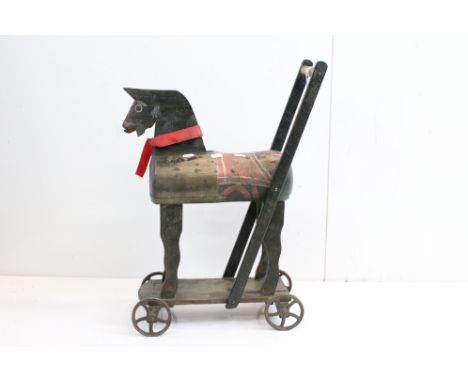 19th Century folk art carved wooden child's horse toy on metal wheels, with painted decoration (approx 60.5cm high) 