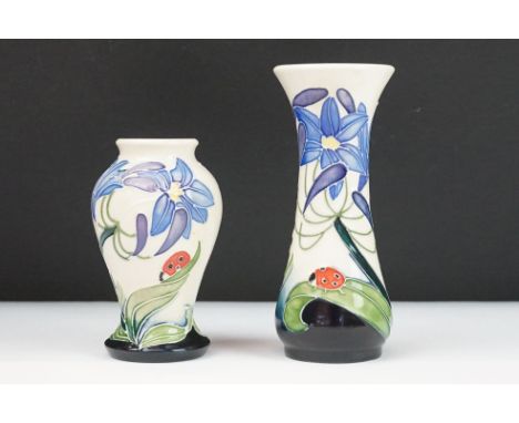 Pair of Moorcroft ceramic vases in the Fly Away Home pattern featuring tube lined florals with lady birds. Stamped to the bas