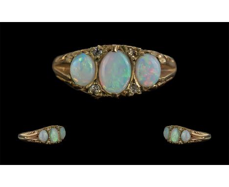 Antique Period Attractive 9ct Gold Three Stone Opal Set Ring with old cut diamond spacers, marked 9ct to shank; the three wel