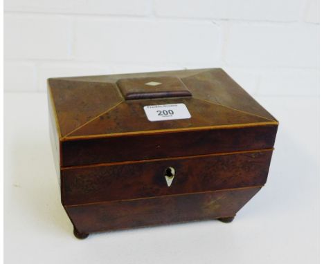 A burr wood sarcophagus tea caddy with two divisions to the interior on four bun feet, 20 x 14cm 