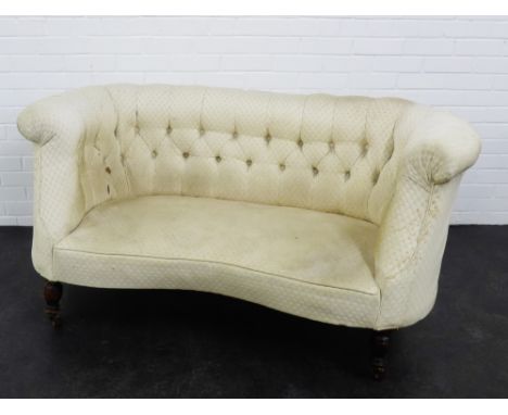An early 20th century upholstered button back sofa of small proportions, on mahogany supports 