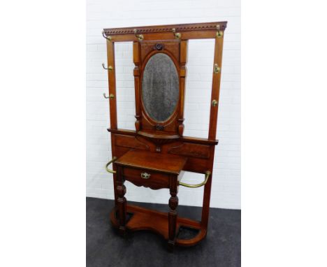 An early 20th century oak hall stand, with central oval mirror back, above a single drawer, with brass fittings to side , 200