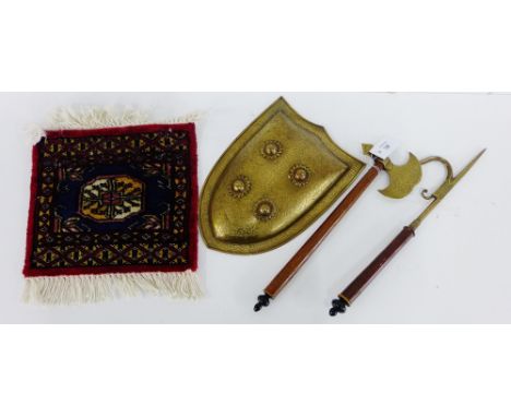 An Indian ceremonial brass shield, axe and pick, all with foliate engraving, together with a small square mat, (4) 