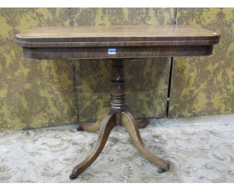 An early 19th century mahogany fold over top tea table of rectangular form with rounded corners, raised on a central turned p