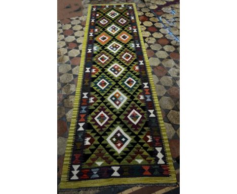 A Maimana Kilim Runner with a lime green border around a field of stepped diamond medallions 292cm x 84cm 