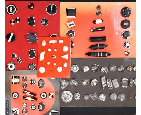 A collection of vintage black and white Art Deco style buttons and toggles of various shapes and sizes displayed in card incl