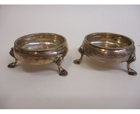 A George III pair of silver circular salts decorated with gadroon rims, standing on three pad feet, London 1767, marked I *M,