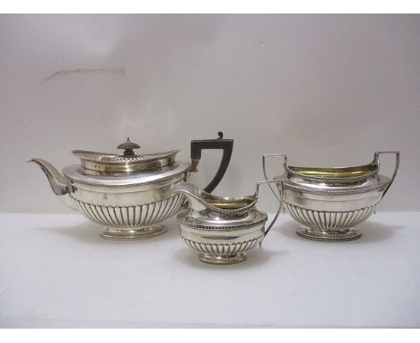 A three piece silver teaset consisting of a teapot, milk jug and sugar bowl all having repousse, gadrooned decoration, by C S