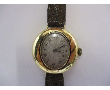 An early 20th century ladies 18ct gold early 20th century wristwatch with oval dial, the oval silvered guilloche dial with Ar