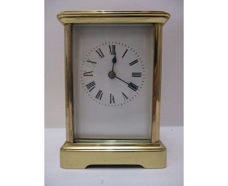 A mid 20th century brass carriage clock, time piece with a folding top handle, visible cylinder escapement, over four glass p