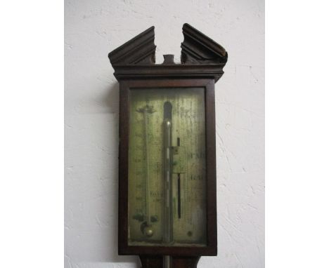 An early 19th century, string inlaid mahogany stick barometer with a broken, arch pediment over a glazed door with a silvered