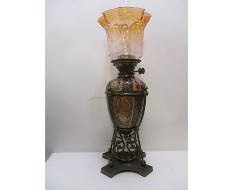 A Doulton Lambeth pottery oil lamp decorated with leaves, owls and fairies in tones of green, brown and blue in a brass tubul