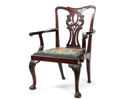 A GEORGE III CHIPPENDALE STYLE MAHOGANY OPEN ARMCHAIR with scrolled, leaf carved, pierced back splat above open sweeping arms