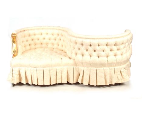 A 19TH CENTURY SERPENTINE SHAPED BUTTON UPHOLSTERED LOVE SEAT standing on square tapering legs with brass casters - 156cm wid