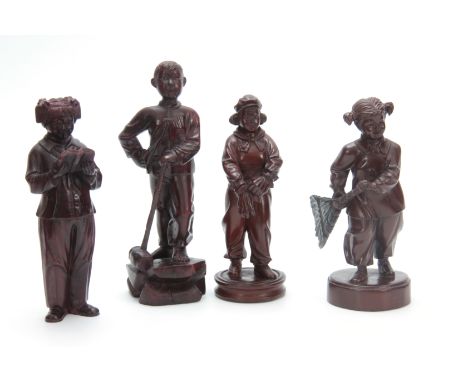 A SET OF FOUR CHINESE CULTURAL REVOLUTION CARVED HARDWOOD FIGURES modelled as boys and girls dressed in the obligatory smock 