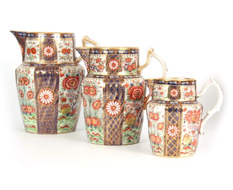 A GOOD GRADUATED SET OF THREE EARLY 19TH CENTURY CHAMBERLAINS WORCESTER JUGS  each decorated and gilded with vibrant floral a